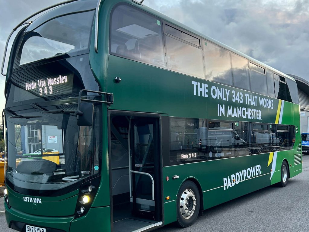 A green Paddy Power branded bus wrap featuring bold campaign graphics and logo promoting the betting company.