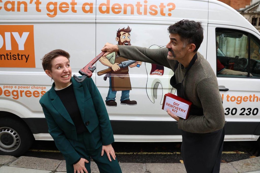 Participants demonstrating the DIY dentistry stunt in front of the 38 Degrees campaign van during the NHS dentistry protest