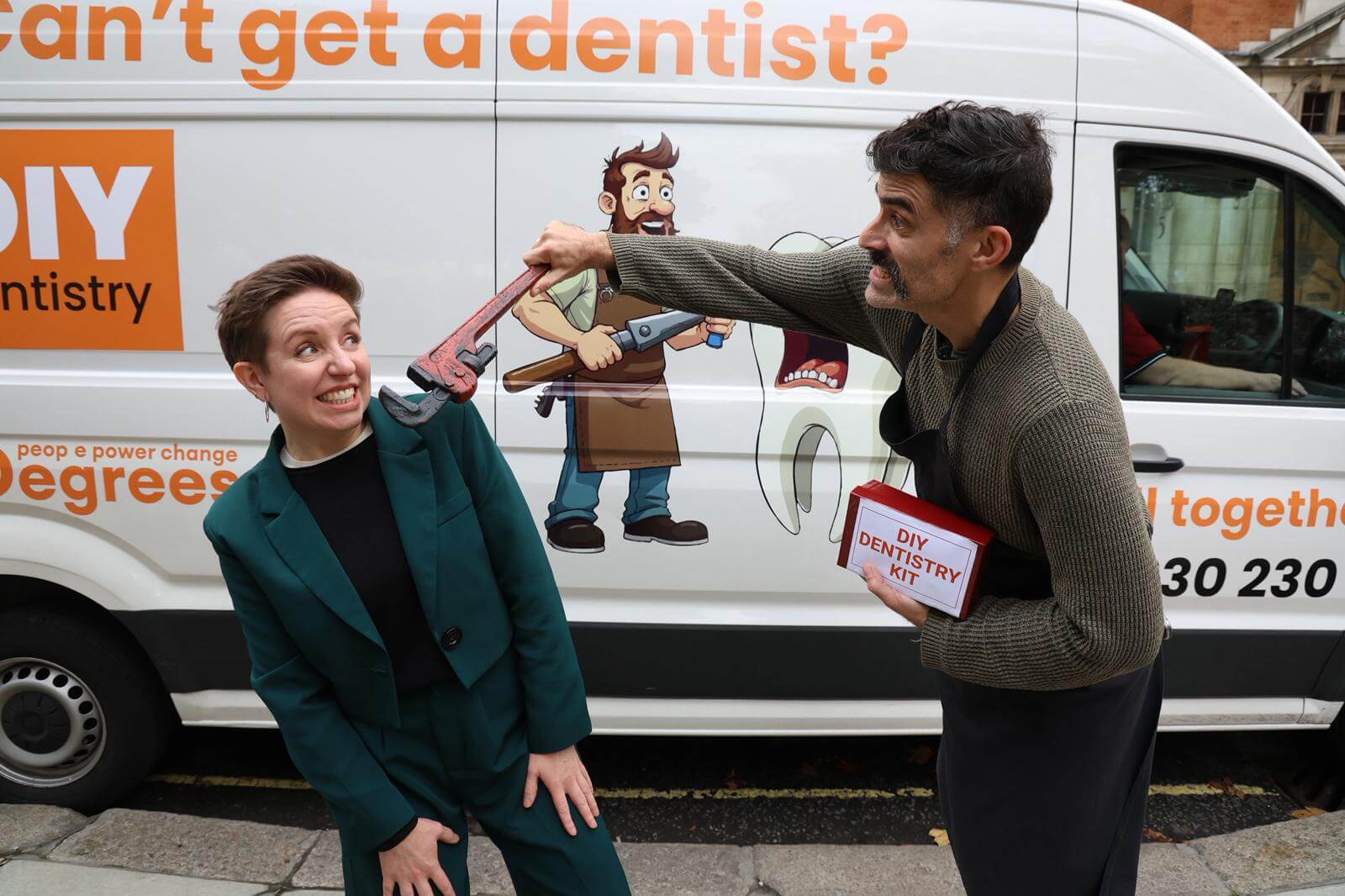Participants demonstrating the DIY dentistry stunt in front of the 38 Degrees campaign van during the NHS dentistry protest